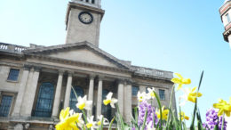 A shot of the Guildhall in Hull. The building is in the background and spring flowers are in the foreground