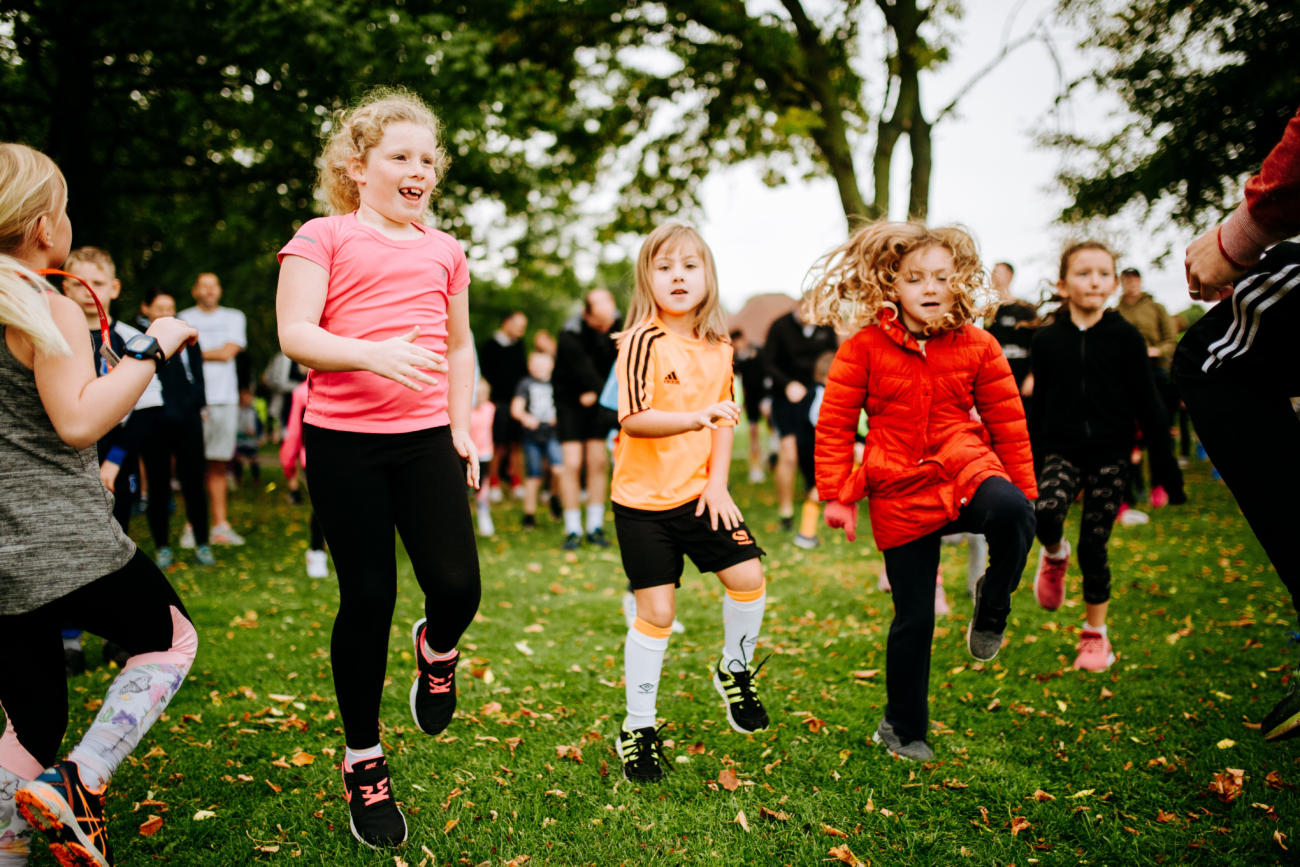 3 children taking part in a group activity on a grassed area