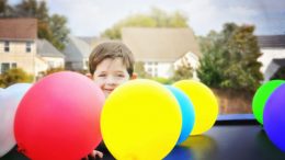 A young boy playing with balloons