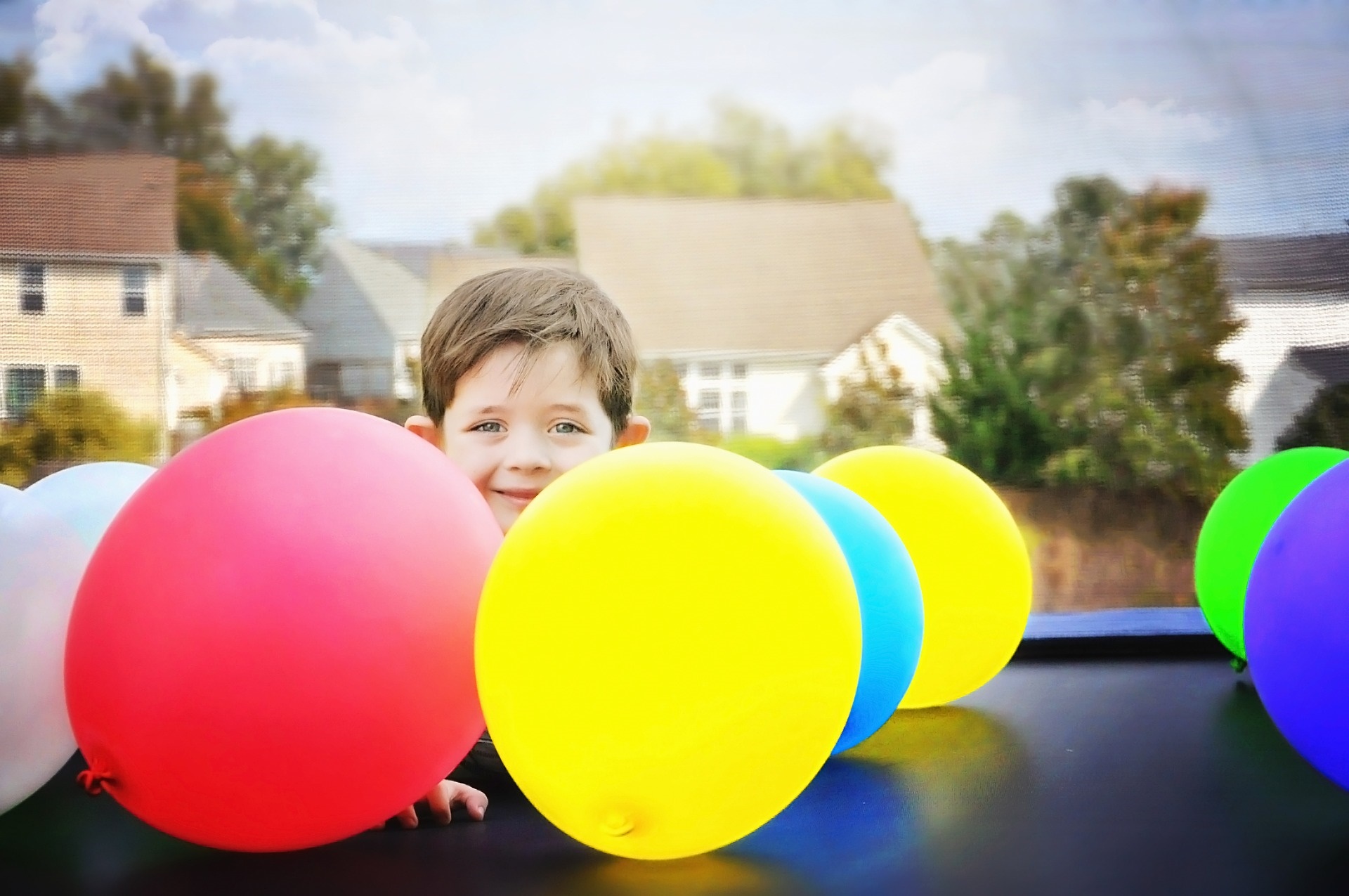 A young boy playing with balloons