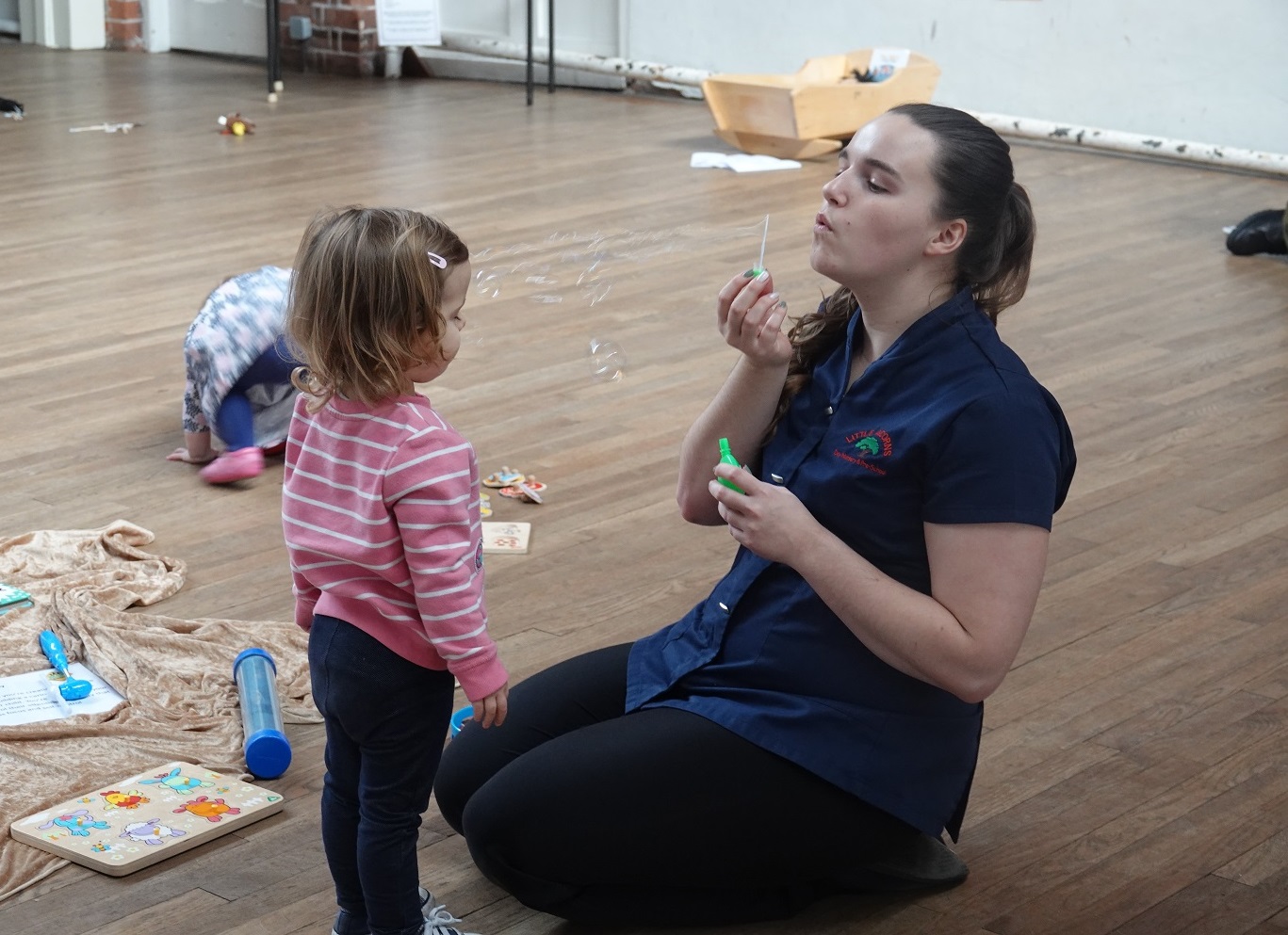 A mum blows bubbles for a child