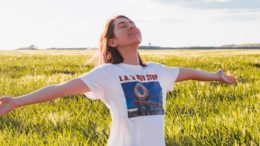a woman stretches her arms in a field