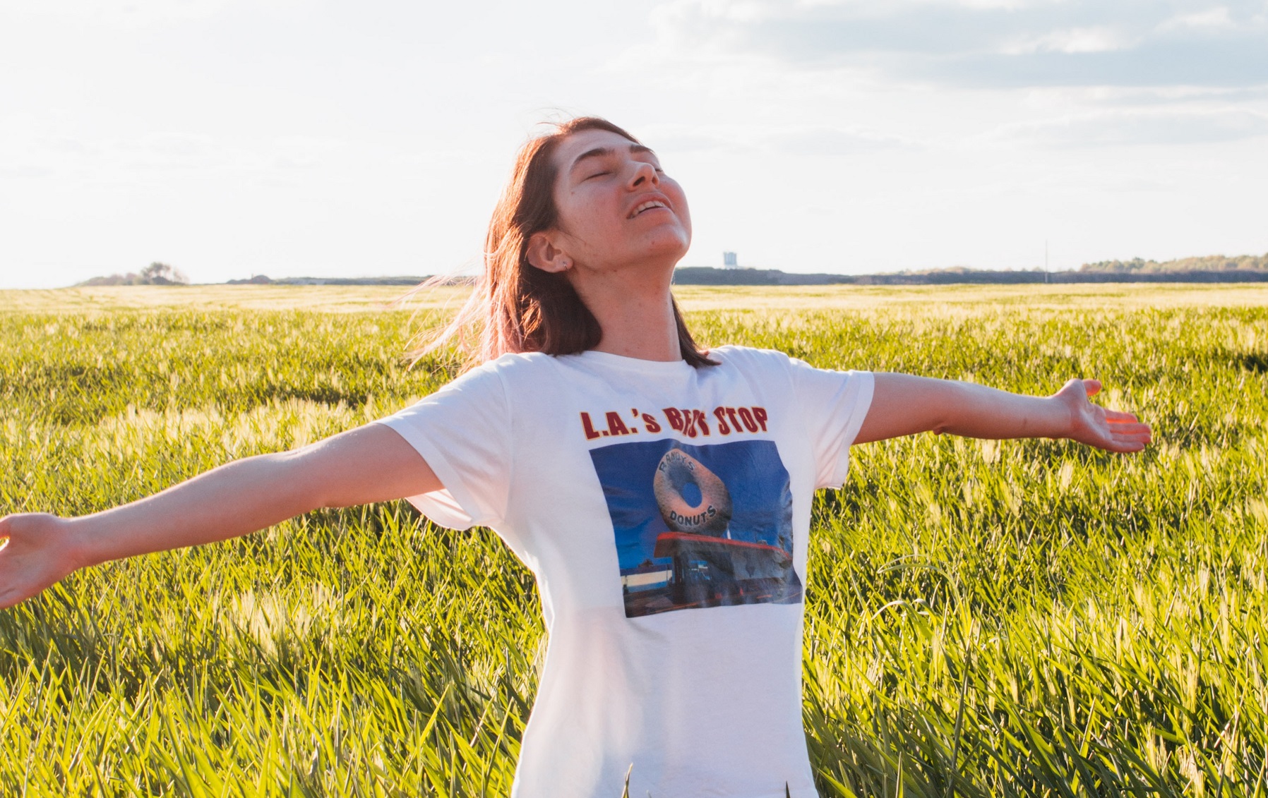 a woman stretches her arms in a field