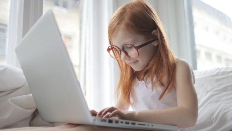 A girl with glasses using a laptop.
