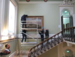 Maritime painting being removed from the walls in the main stairwell of the Maritime Museum