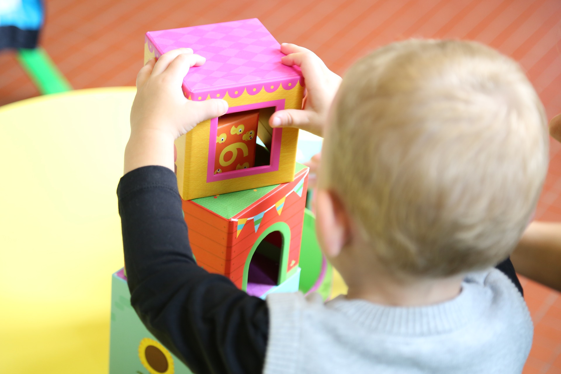 A young boy playing with some colourful building blocks.