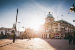 The sun shining over Hull City Hall and onto Queen Victoria Square.