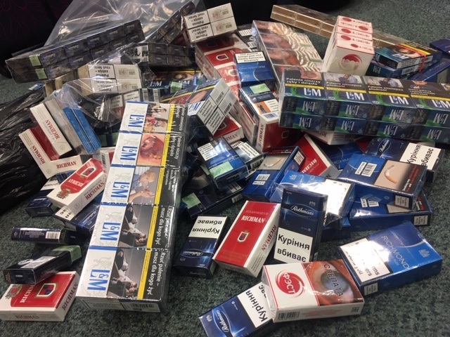 a large number of illicit cigarettes in a pile, still in their packaging
