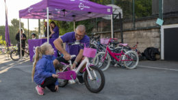 A R-evolution cycle expert helps a young girl with her bike