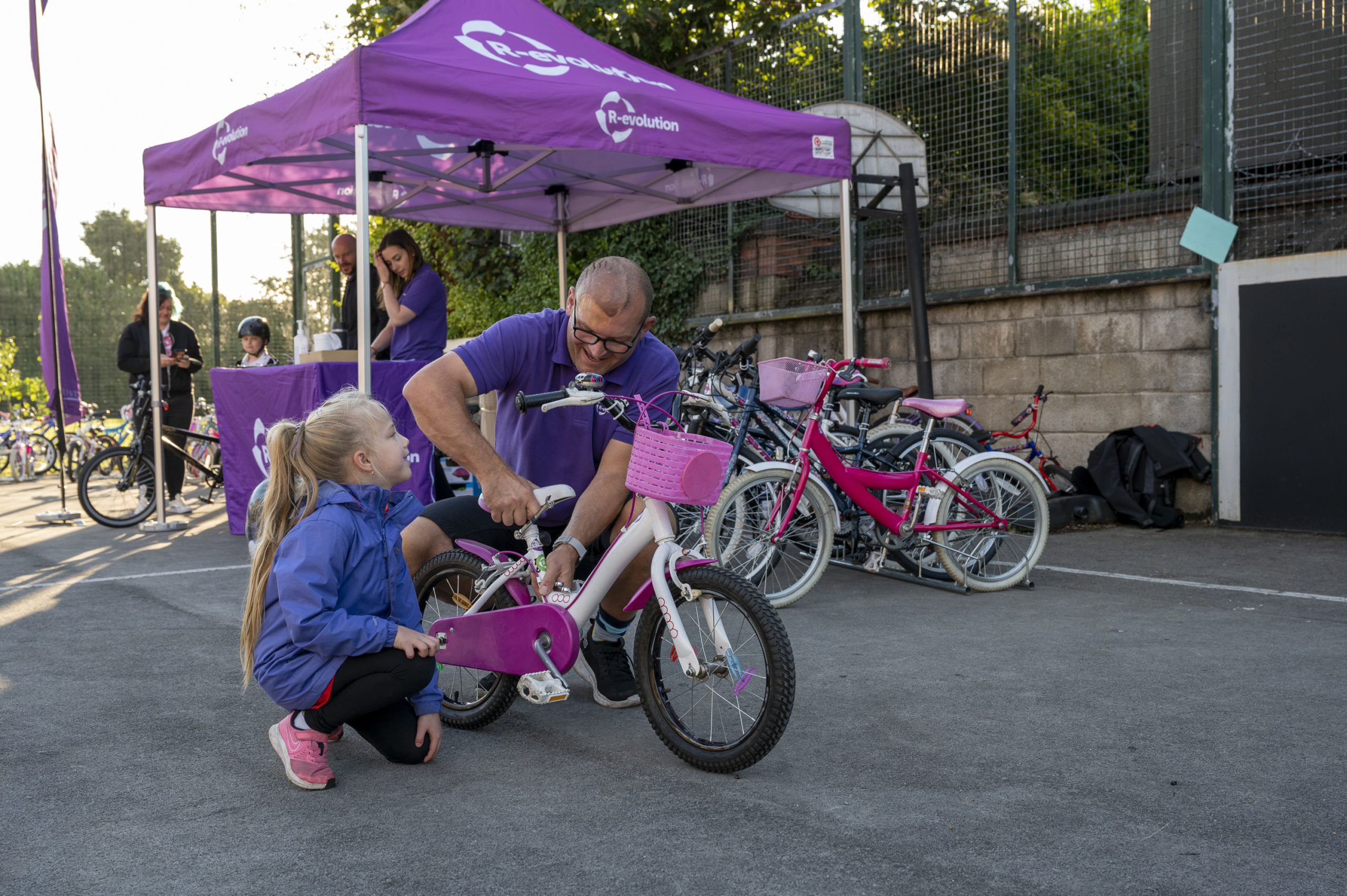 A R-evolution cycle expert helps a young girl with her bike