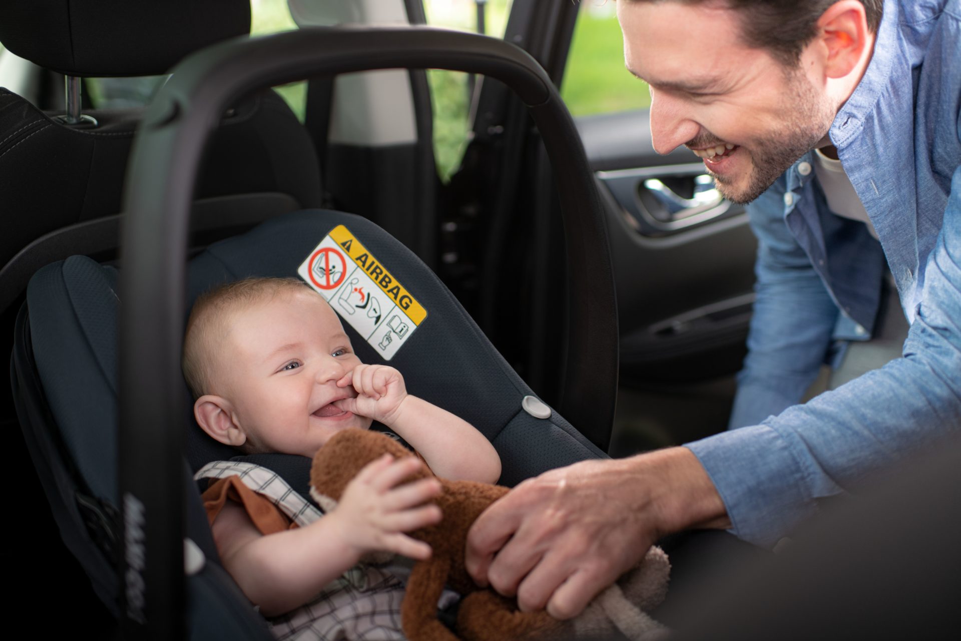 A parent with infant in car seat