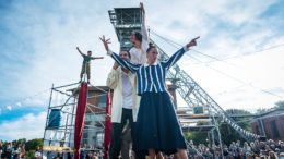 Outdoor theatre performers raising hands to crowd