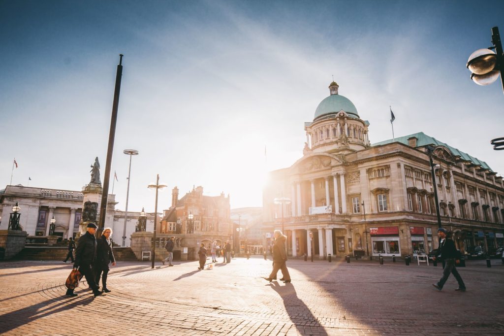 The sun shining over Hull City Hall and onto Queen Victoria Square.