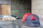 A tent and possessions belonging to a homeless person in a corner