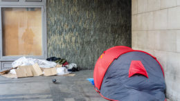 A tent and possessions belonging to a homeless person in a corner