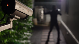 Posed image of a CCTV camera capturing a thief breaking into a house during the night