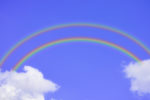 An illustration of a double rainbow with clouds either end, in a blue sky