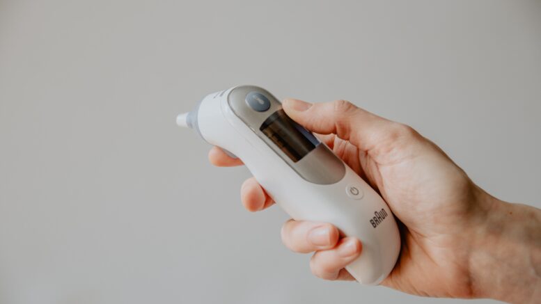 a hand holds a digital thermometer