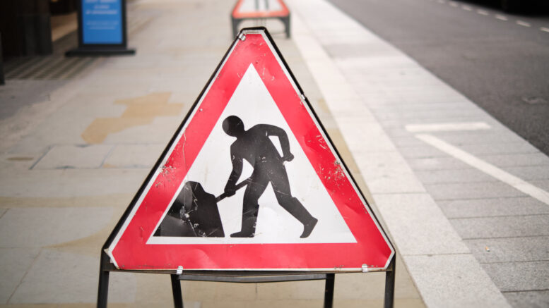 Close-up of a roadworks sign on a pavement