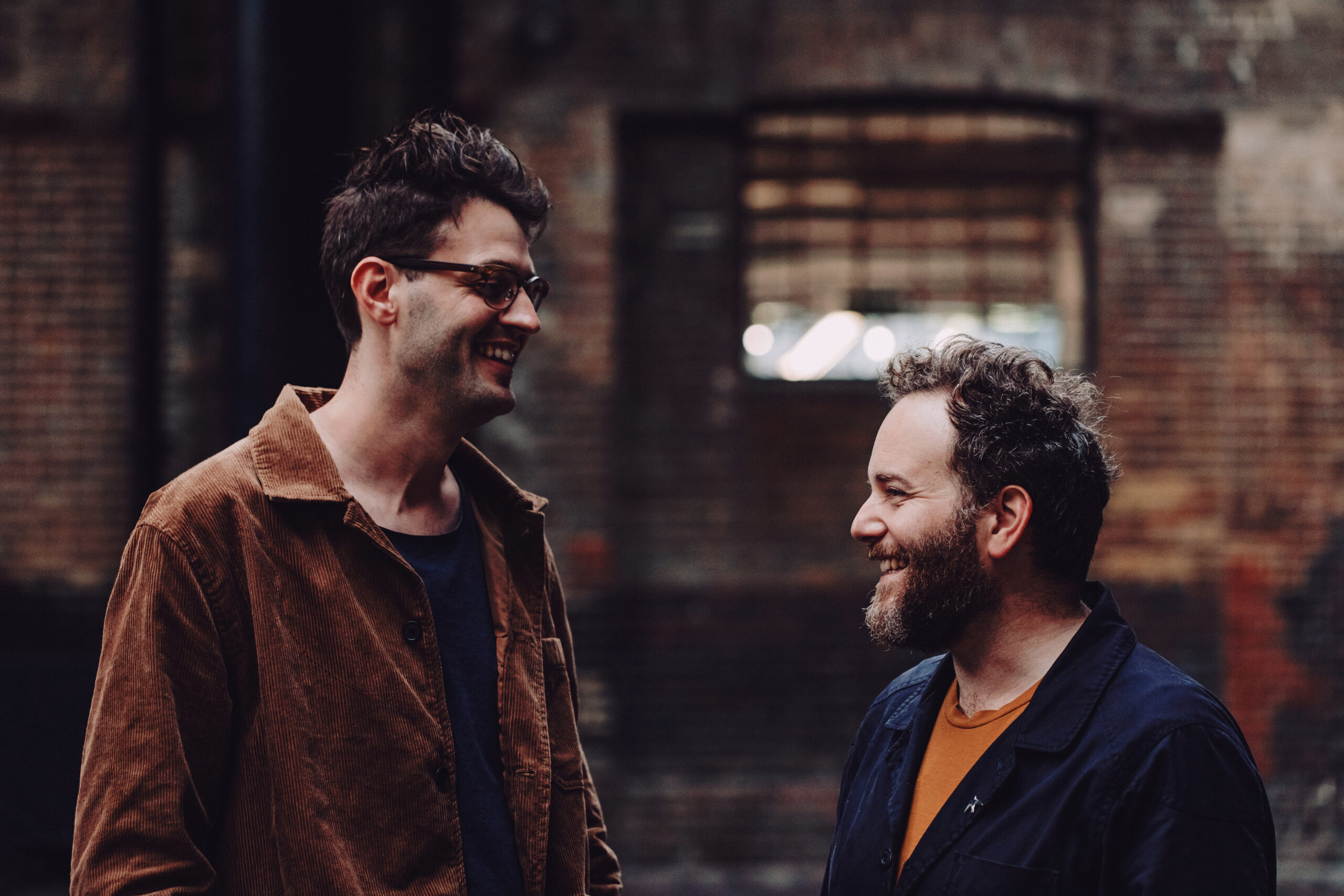 2 males looking at each other smiling