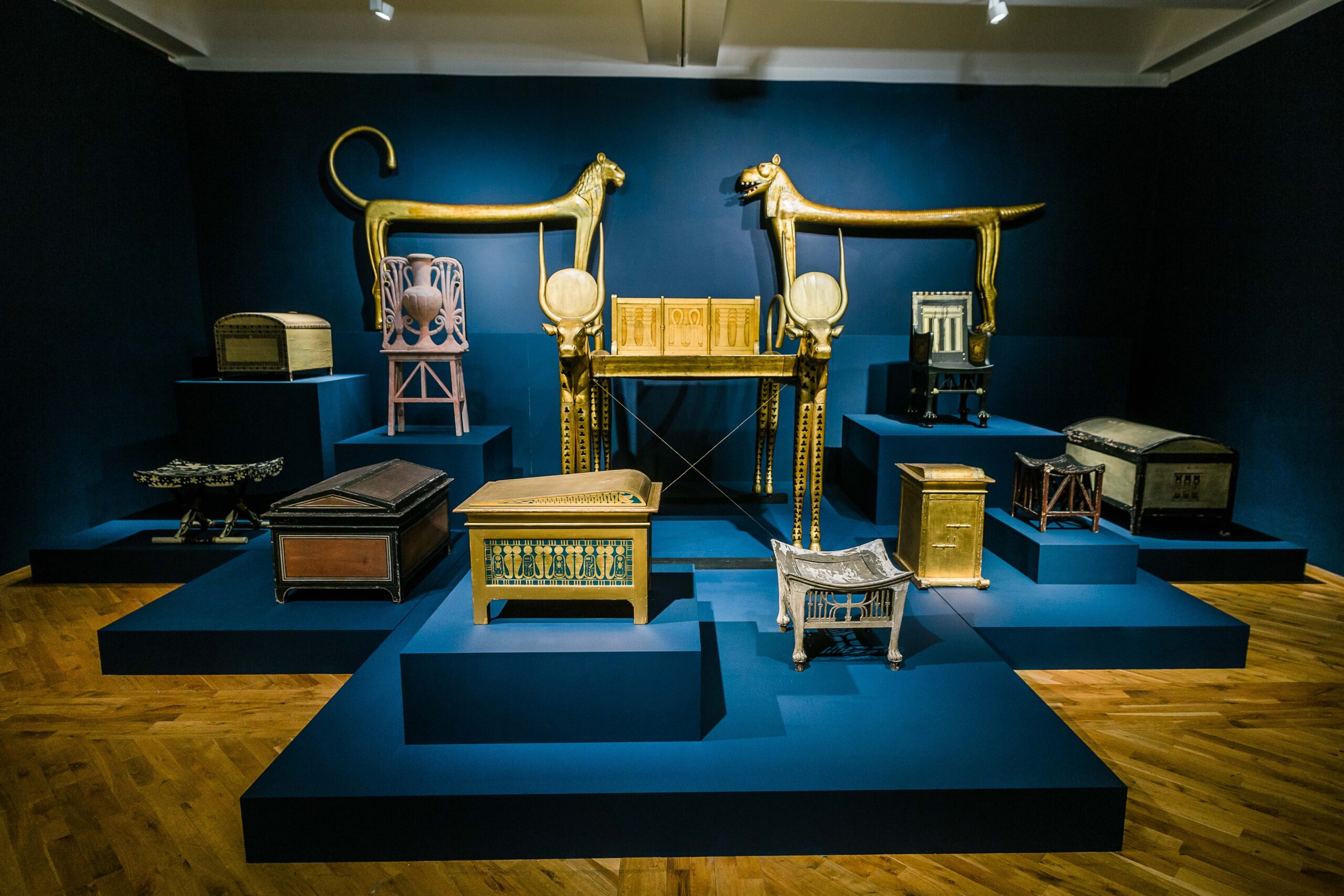 A selection of gold pieces from the collection against a dark blue wall