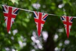 Union Jack bunting flags flying in front of trees