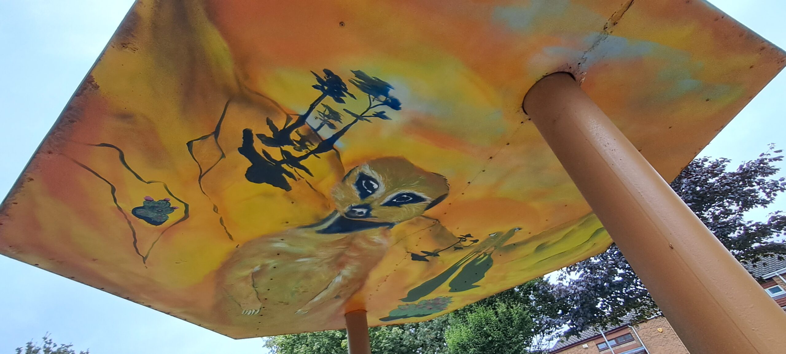 The ceiling of a bus shelter painted with a meerkat in a dessert scene
