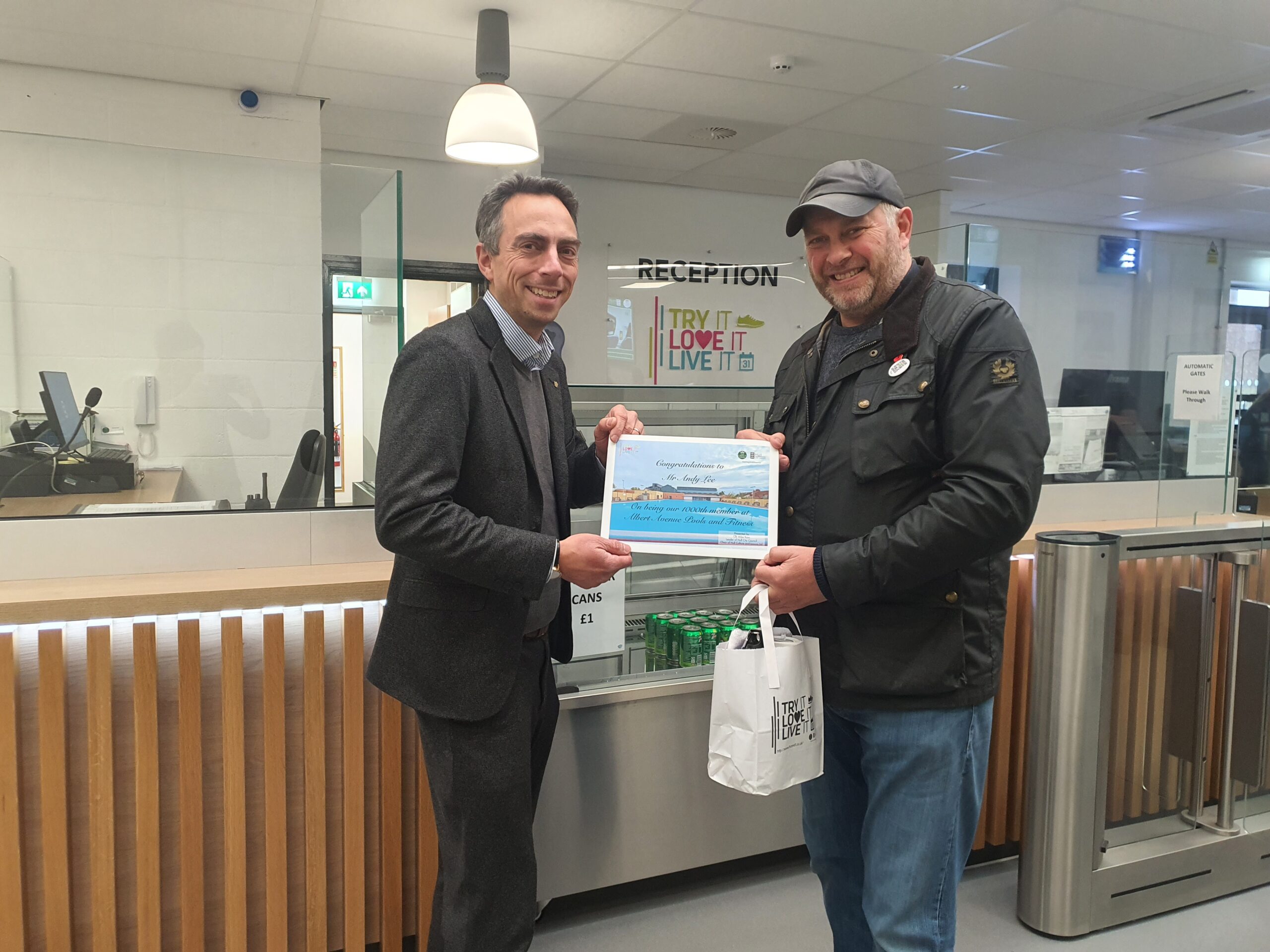 Cllr Mike Ross presents Andy Lee with a 1000th member certificate and goody bag at Albert Ave reception