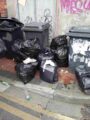 Waste fly-tipped by Samuel Litchfield of Stanley Street, Hull. Imager shows several black bags full of waste on the ground next to three black bins.