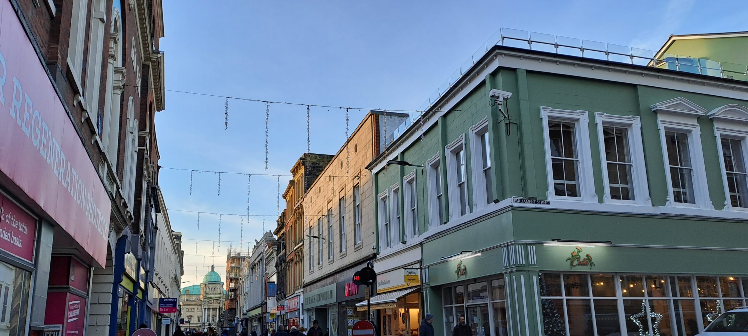 Christmas lights strung across street between buildings and shops