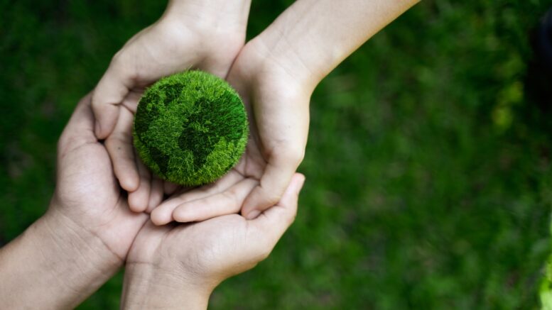 Hands holding a green world.
