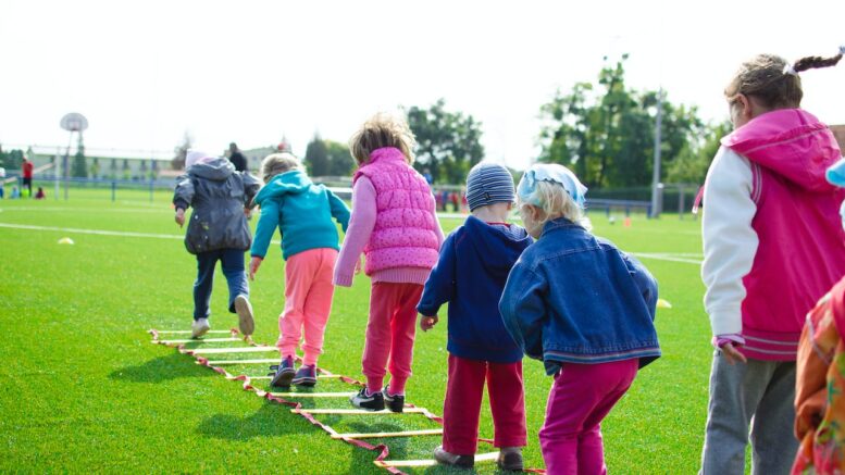 Children playing a ladder game in a field.