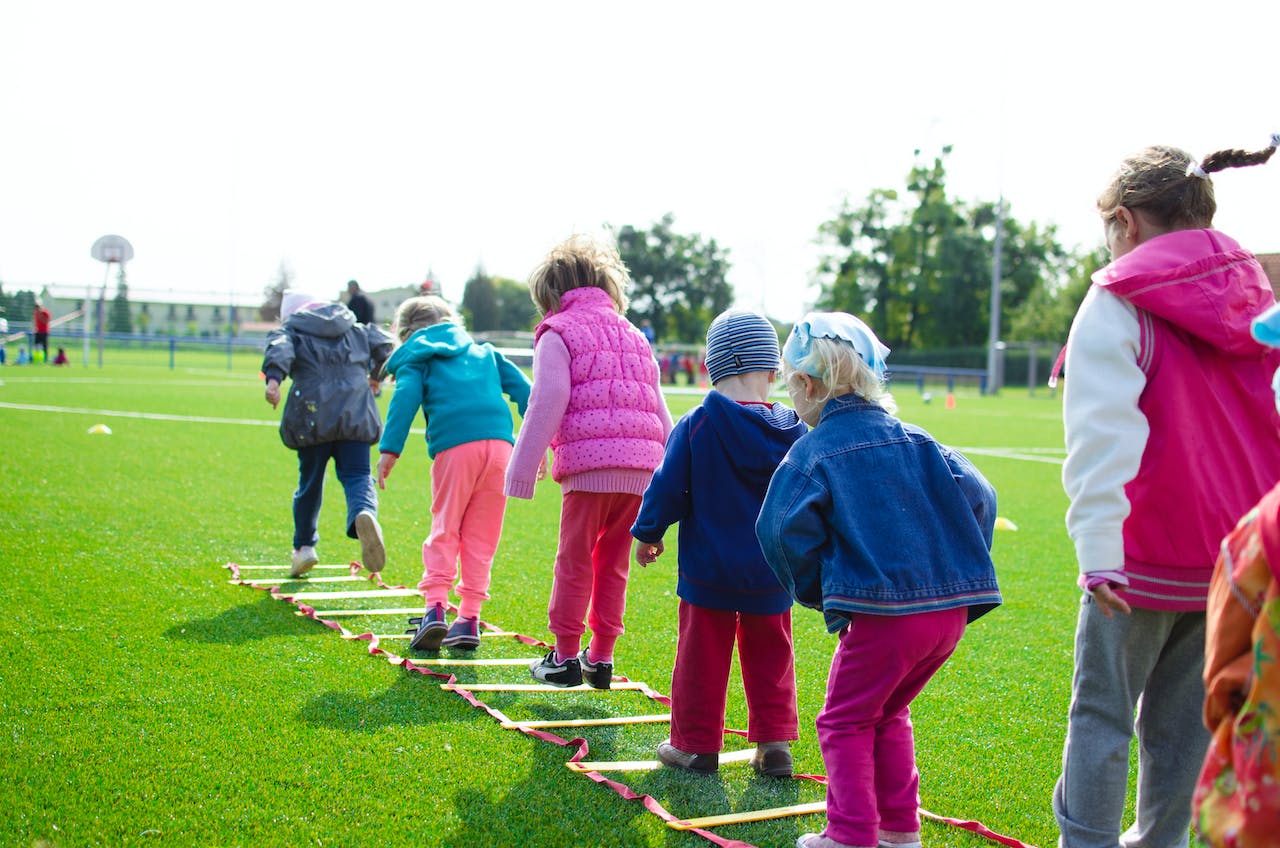 Children playing a ladder game in a field.