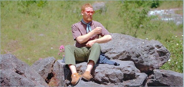 Man in sunglasses sitting on a rock