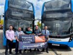 Stagecoach staff stood by two buses with a sign which reads Stagecoach Fostering Friendly.