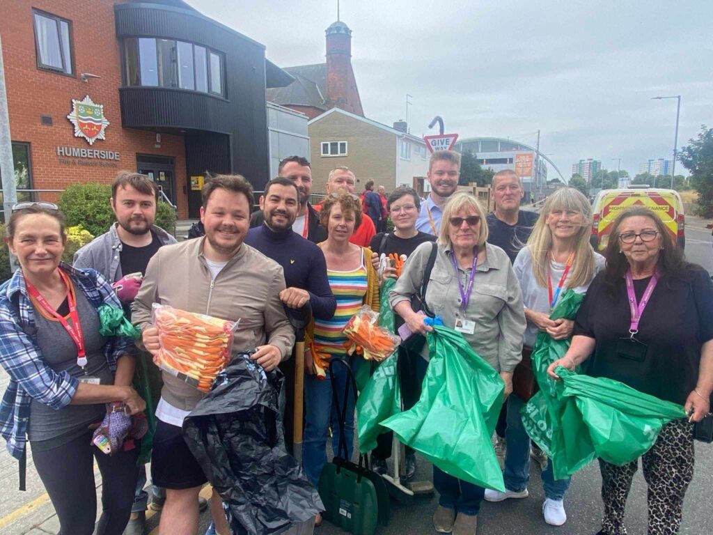 Hull city councillors pose with volunteers with cleaning equipment.