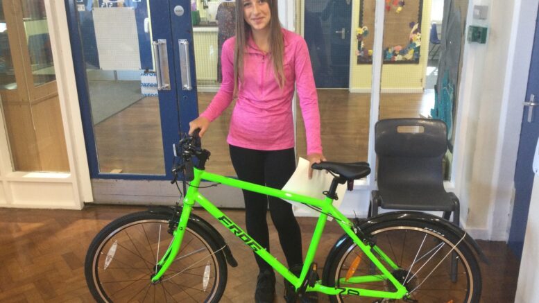 A student from Stockwell Primary School is presented with a Frog bike.