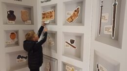 A boy at the new interactive wall at Museum of Archaeology.