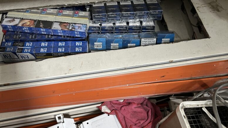 dozens of packets of counterfeit cigarettes, concealed in a unit