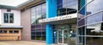 A building with floor to roof windows and Freedom Centre sign above double doors