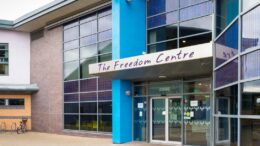 A building with floor to roof windows and Freedom Centre sign above double doors