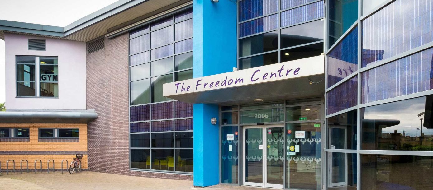 A building with floor to roof windows and Freedom Centre sign above double doors