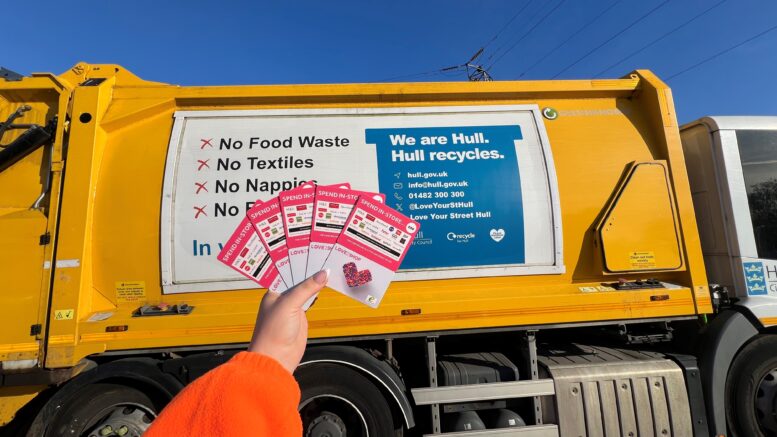 Love 2 Shop vouchers in front of waste vehicle.