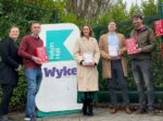 representatives from the council and its partners stand at the entrance to Wyke College, holding examples of the bleed kit boxes and contents