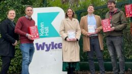 representatives from the council and its partners stand at the entrance to Wyke College, holding examples of the bleed kit boxes and contents