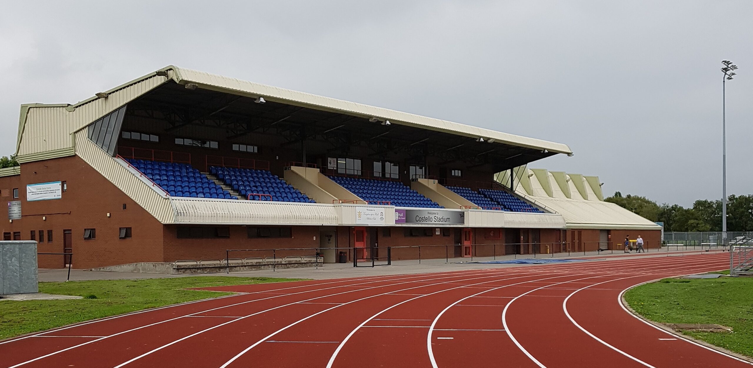 A close up of Costello Stadium running track with the stand in the background.