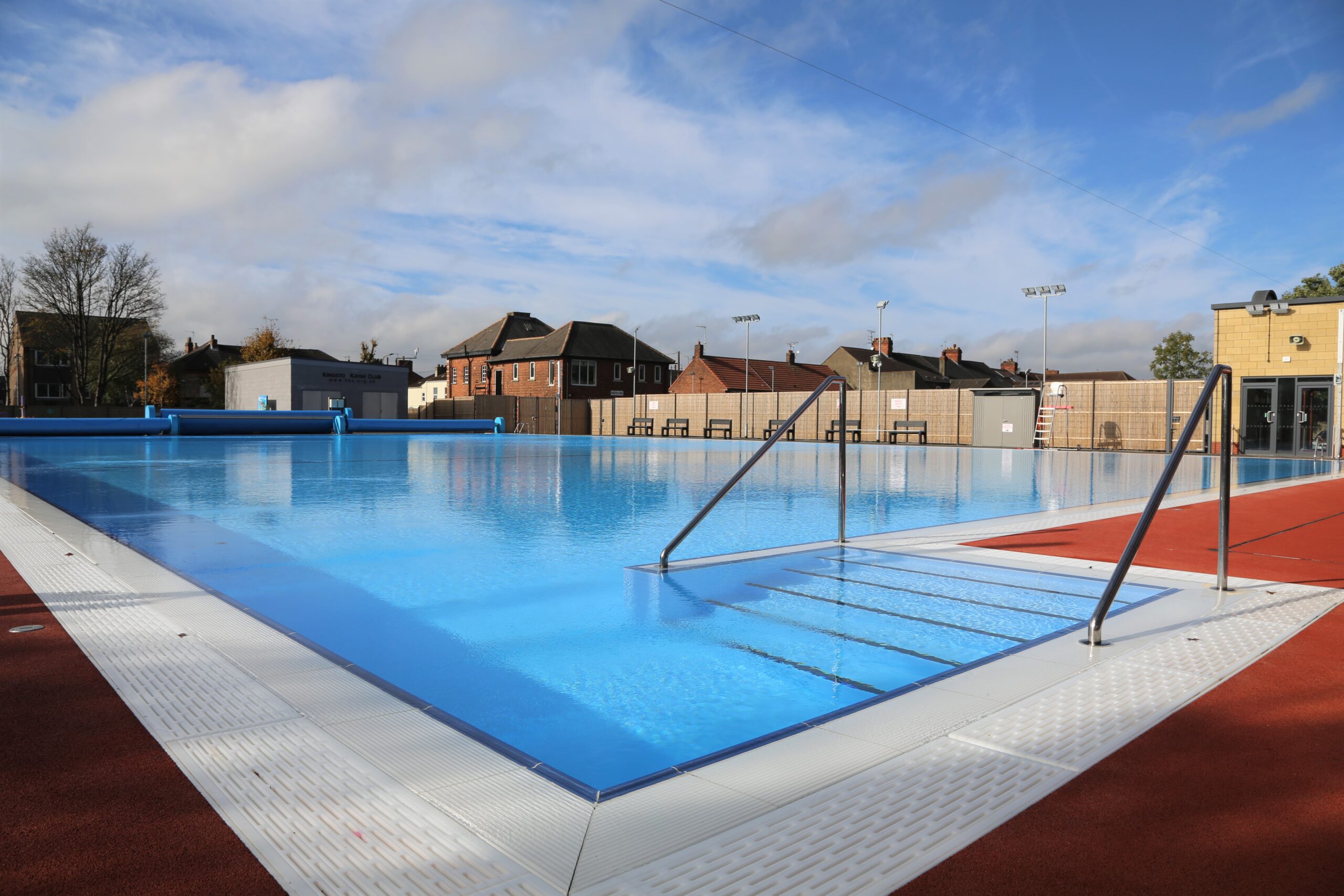 An outdoor pool shining in the sunshine with blue skies