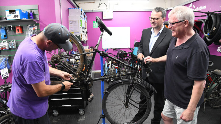 Councillor Mark Ieronimo and Fergal McCullough discuss cycle maintenance with one of R-evolution’s trained mechanics at the Trinity Market Cycle Hub
