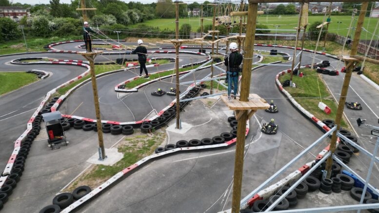 Karts race below those tackling the new high ropes course.