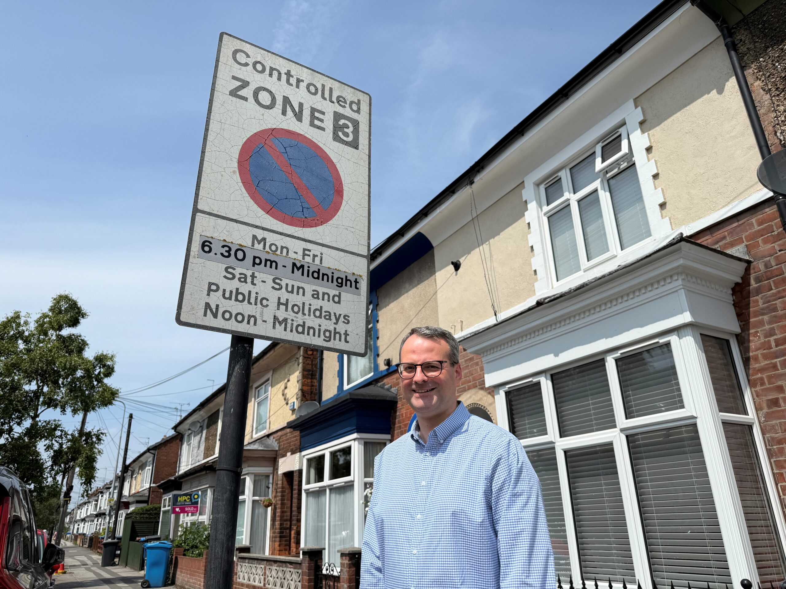 Councillor Mark Ieronimo, portfolio holder for transportation and infrastructure, standing in-front of a controlled parking zone sign.